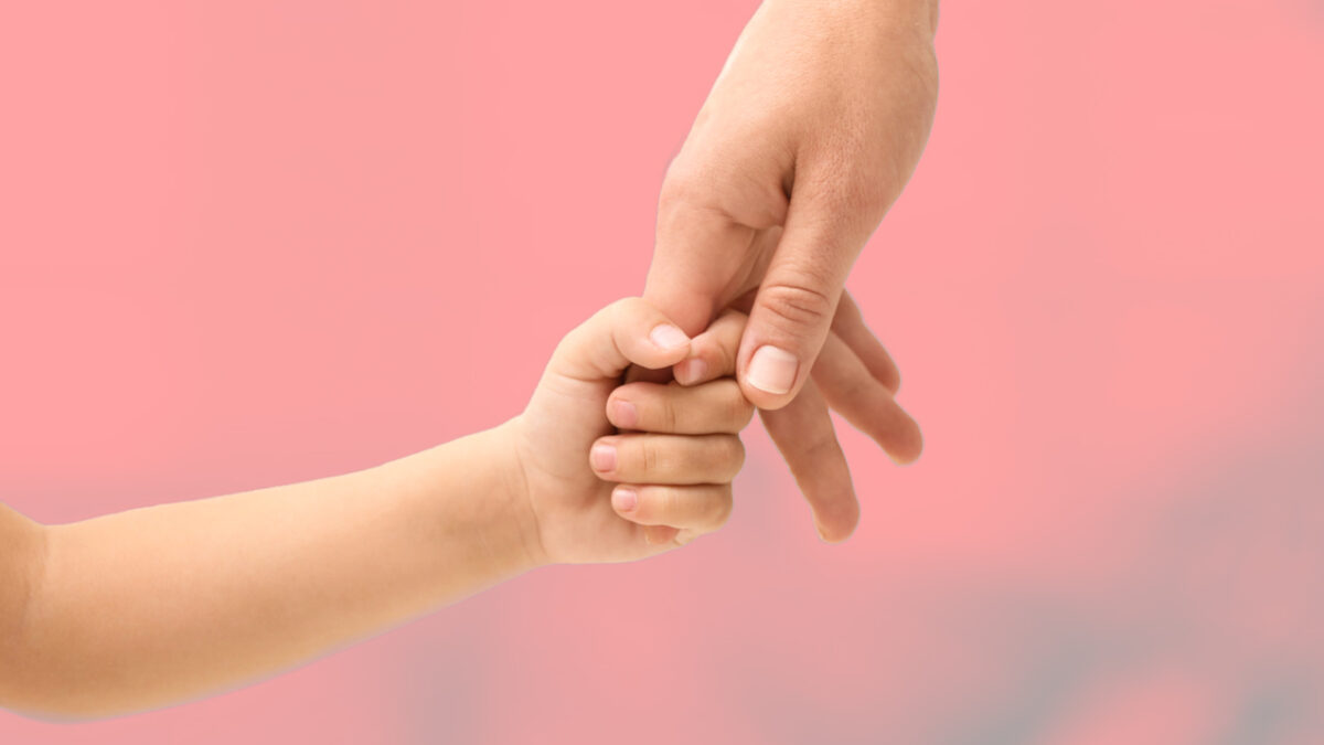 Imagen de un bebé dando la mano a su madre.