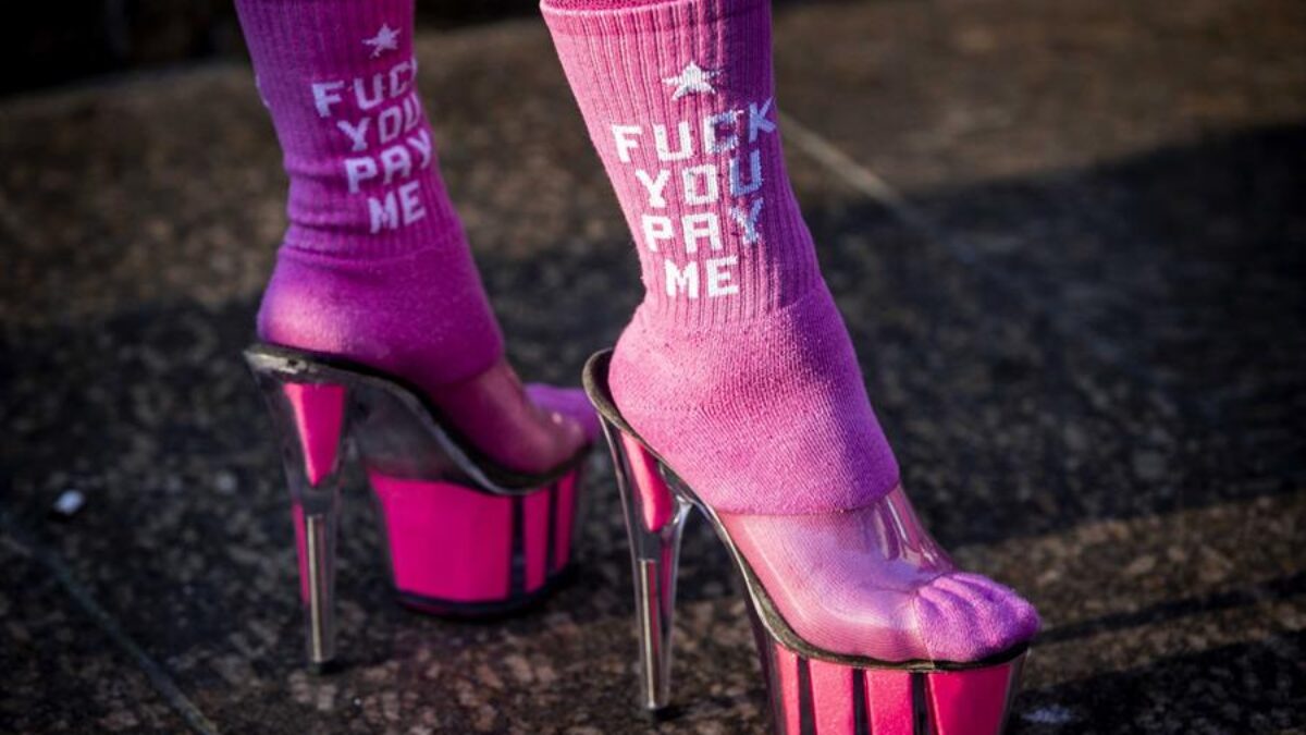 Una trabajadora sexual con tacones y calcetines rosas