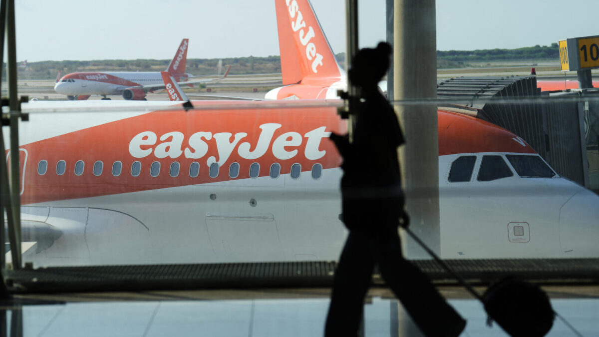 Una pasajera mientras pasa delante de un avión de la aerolínea easyJet en el Aeropuerto de El Prat de Barcelona
