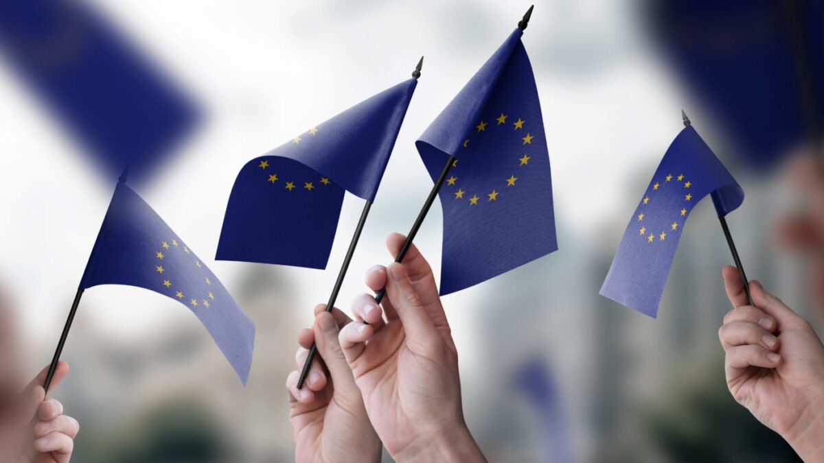 Un grupo de personas con banderas de la Unión Europea en sus manos.