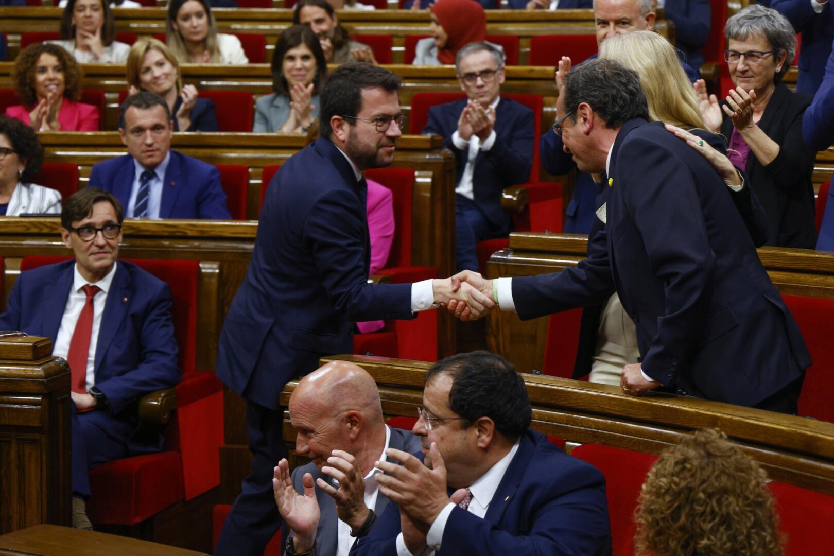 Josep Rull es felicitado por Pere Aragonès ante la mirada de Salvador Illa.