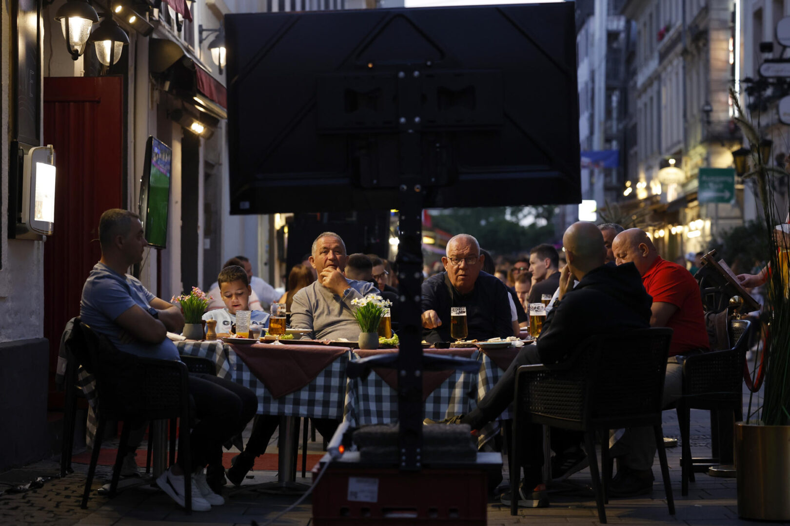 Aficionados miran en las televisiones instaladas en un bar.