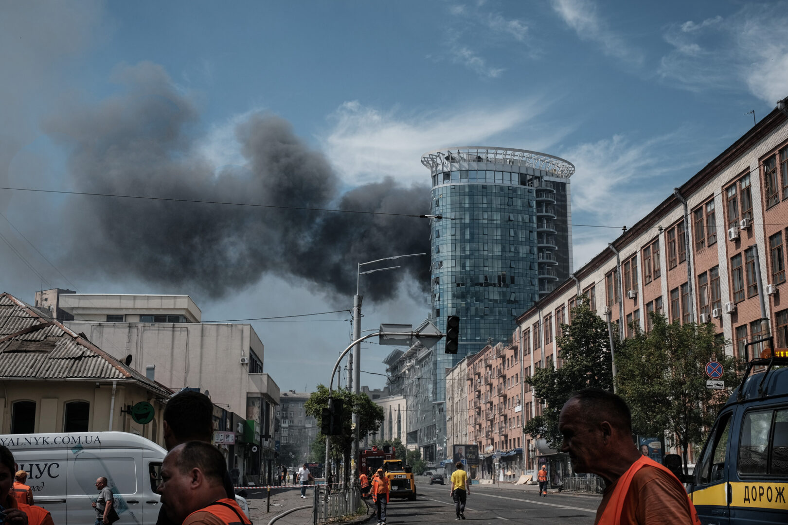 Una columna de humo emerge de un edificio bombardeado por Rusia, en Kiev, mientras los operarios de emergencias intentan controlar los daños