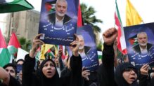 Iraníes sostienen fotografías del difunto líder de Hamás, Ismail Haniyeh, durante una protesta en la plaza Palestina en Teherán, Irán