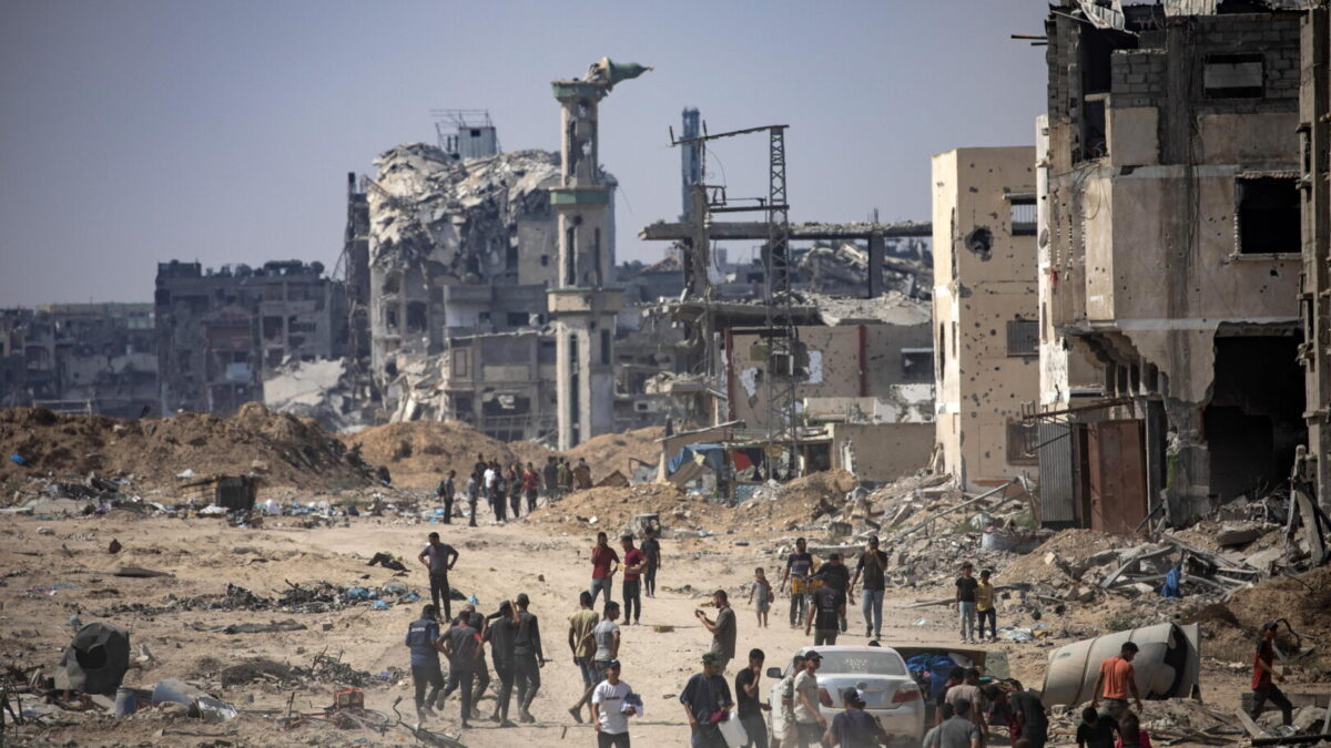 Palestinos desplazados inspeccionan la zona destruída después de bombardeos israelíes en el campamento de Khan Younis, sur de la Franja de Gaza.