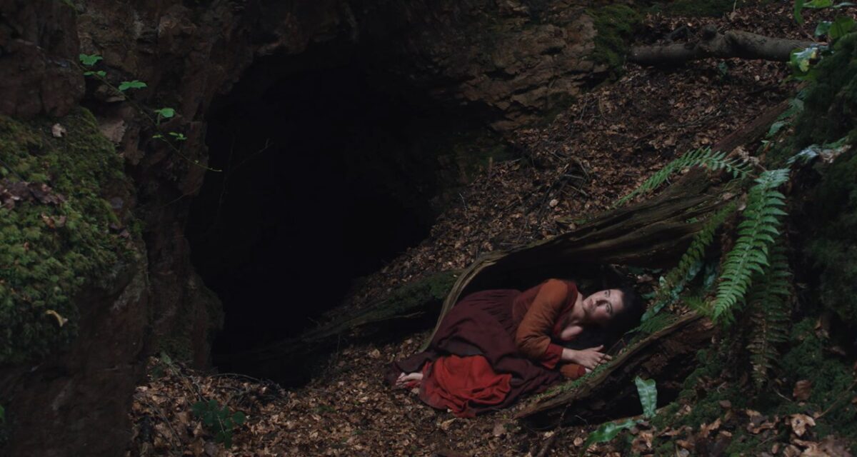 Agnes (Jessie Buckley) en el agujero metafórico del bosque en 'Hamnet'