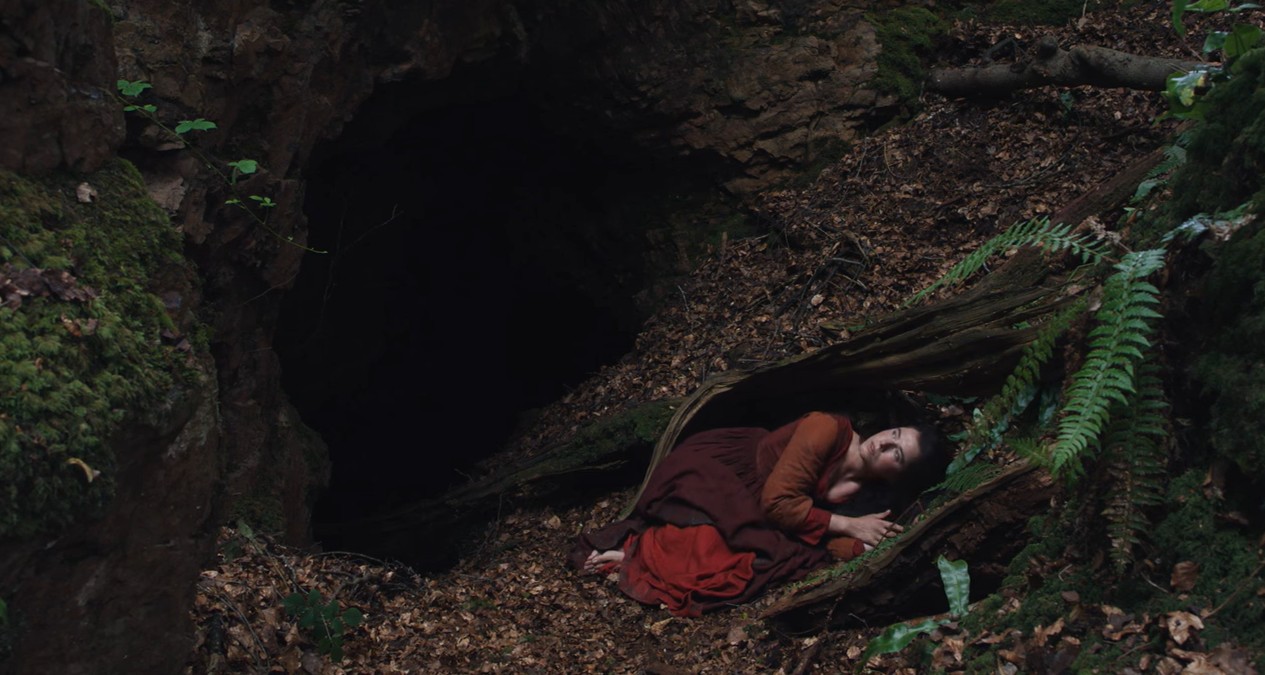 Agnes (Jessie Buckley) en el agujero metafórico del bosque en 'Hamnet'