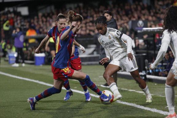Linda Caicedo disputa un balón con Graham Hansen