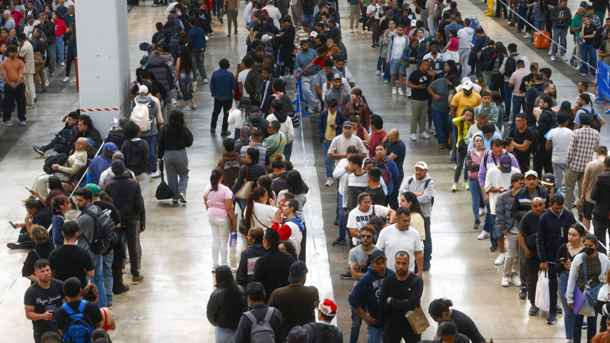 Centenares de inmigrantes hacen cola en el recinto ferial La Farga de L'Hospitalet de Llobregat (Barcelona.
