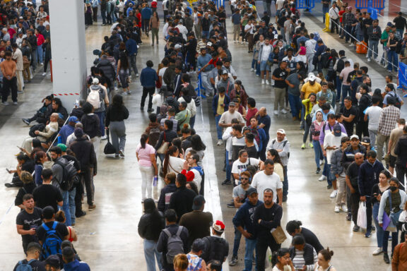 Centenares de inmigrantes hacen cola en el recinto ferial La Farga de L'Hospitalet de Llobregat (Barcelona.