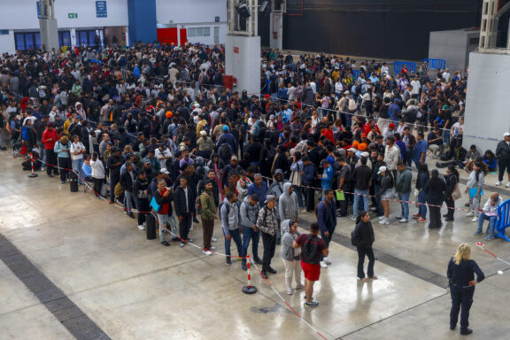 GRAFCAT1604. L'HOSPITALET DE LLOBREGAT (BARCELONA) (ESPAÑA), 21/04/2026.- Centenares de personas migrantes vuelven a hacer cola desde primera hora de este martes en el recinto ferial La Farga de L'Hospitalet de Llobregat (Barcelona) para conseguir los documentos que faciliten su regularización en España, en el marco del proceso extraordinario abierto por el Gobierno.