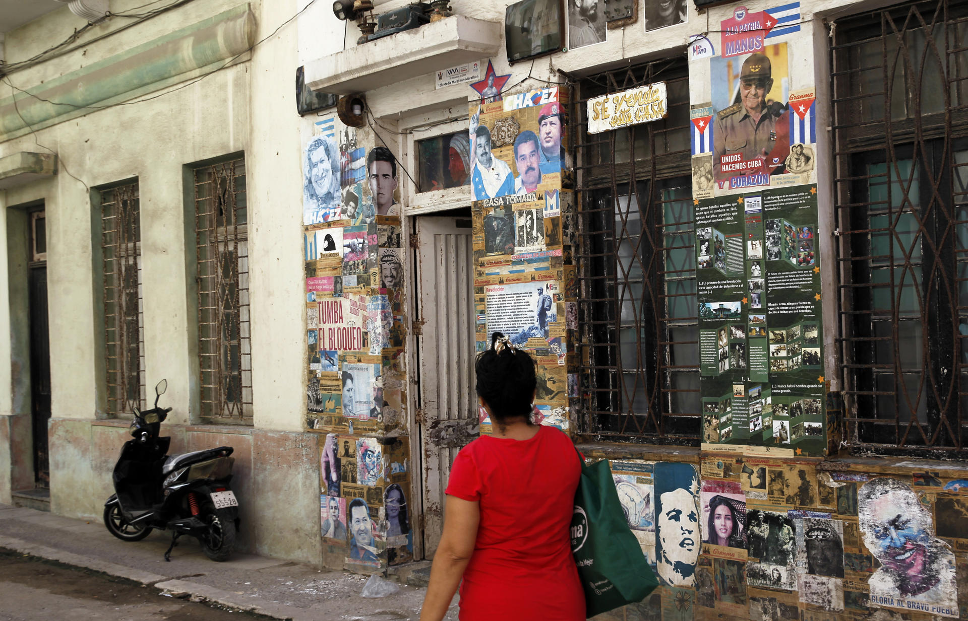 AME3439. LA HABANA (CUBA), 20/05/2026.- Una persona camina frente a una casa con carteles y propaganda política en su fachada este miércoles, en la Habana (Cuba). El Departamento de Justicia (DOJ) de Estados Unidos presentó una acusación criminal contra el expresidente cubano Raúl Castro por la muerte de cuatro aviadores de la organización Hermanos al Rescate hace 30 años, lo que eleva la presión contra La Habana. EFE/ Ernesto Mastrascusa