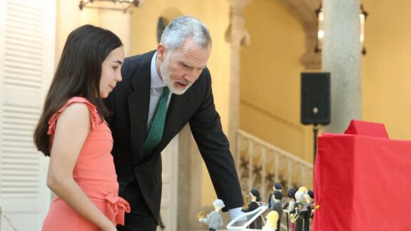 Don Felipe escucha las explicaciones de los alumnos sobre los proyectos premiados