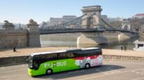 Una imagen conceptual de un autobús con el Puente de las Cadenas de fondo.