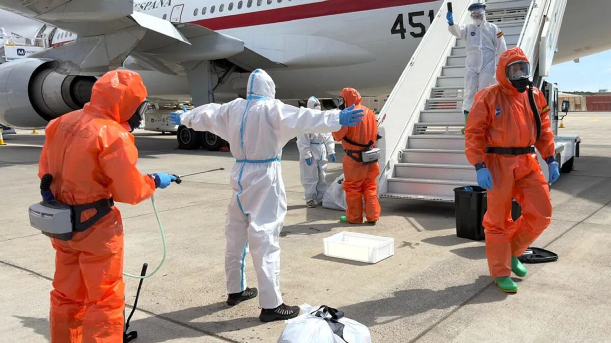 Un pasajero español es rociado con desinfectante por funcionarios del Gobierno español antes de subir a un avión tras desembarcar del crucero, afectado por el hantavirus, en el aeropuerto de Tenerife.
