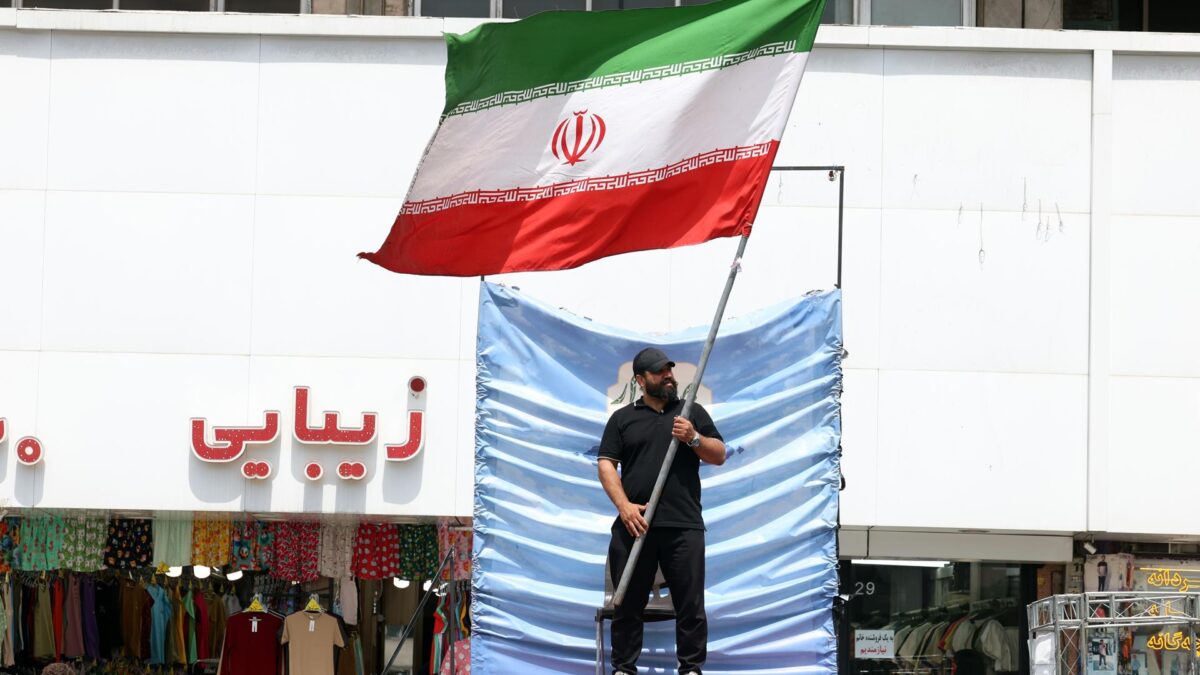 TEHRAN (IRAN(Islamic Republic Of)), 28/05/2026.- A man holds Irans national flag at the Valiasr Square in Tehran, Iran, 28 May 2026. US President Donald Trump recently announced that a potential peace agreement to end the conflict and reopen the Strait of Hormuz has been largely negotiated through Pakistani mediators. However, the US has since launched new strikes in southern Iran. (Teherán) EFE/EPA/ABEDIN TAHERKENAREH RESTRICTIONS: NO Access Israel Media/Persian Language TV Stations Outside Iran/Strictly No Access BBC Persian/VOA Persian/Manoto TV/Iran International TV. (As mandated by Iran's Directorate General for Foreign Media) --