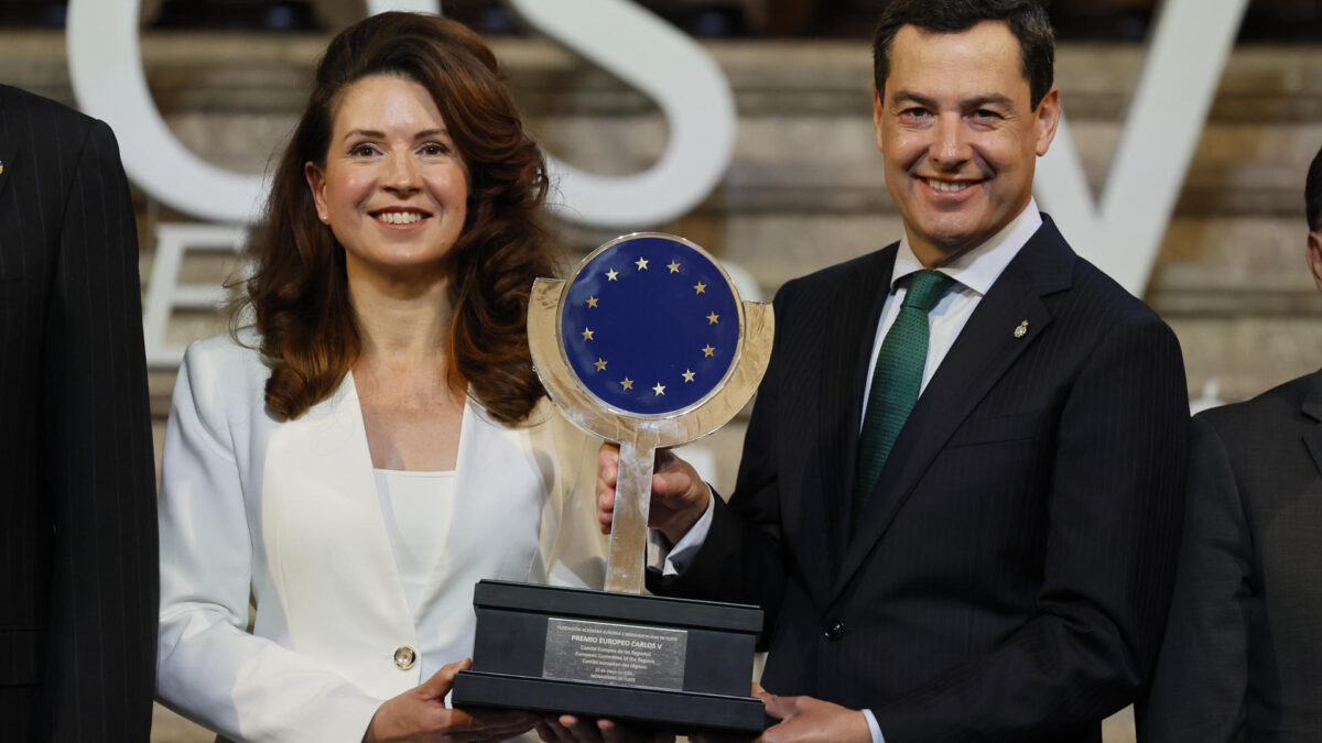 CUACOS DE YUSTE (CÁCERES) (ESPAÑA), 25/05/2026.- La presidenta del Comité Europeo de las Regiones (CDR), Kata Tütto (i) sostiene el Premio Carlos V al Comité de las Regiones de la UE junto a al presidente en funciones de la Junta de Andalucía, Juanma Moreno (d) durante el acto de entrega del XIX Premio Europeo Carlos V celebrado este lunes en el Monasterio de San Jerónimo de Yuste (Cáceres). EFE/ Ballesteros