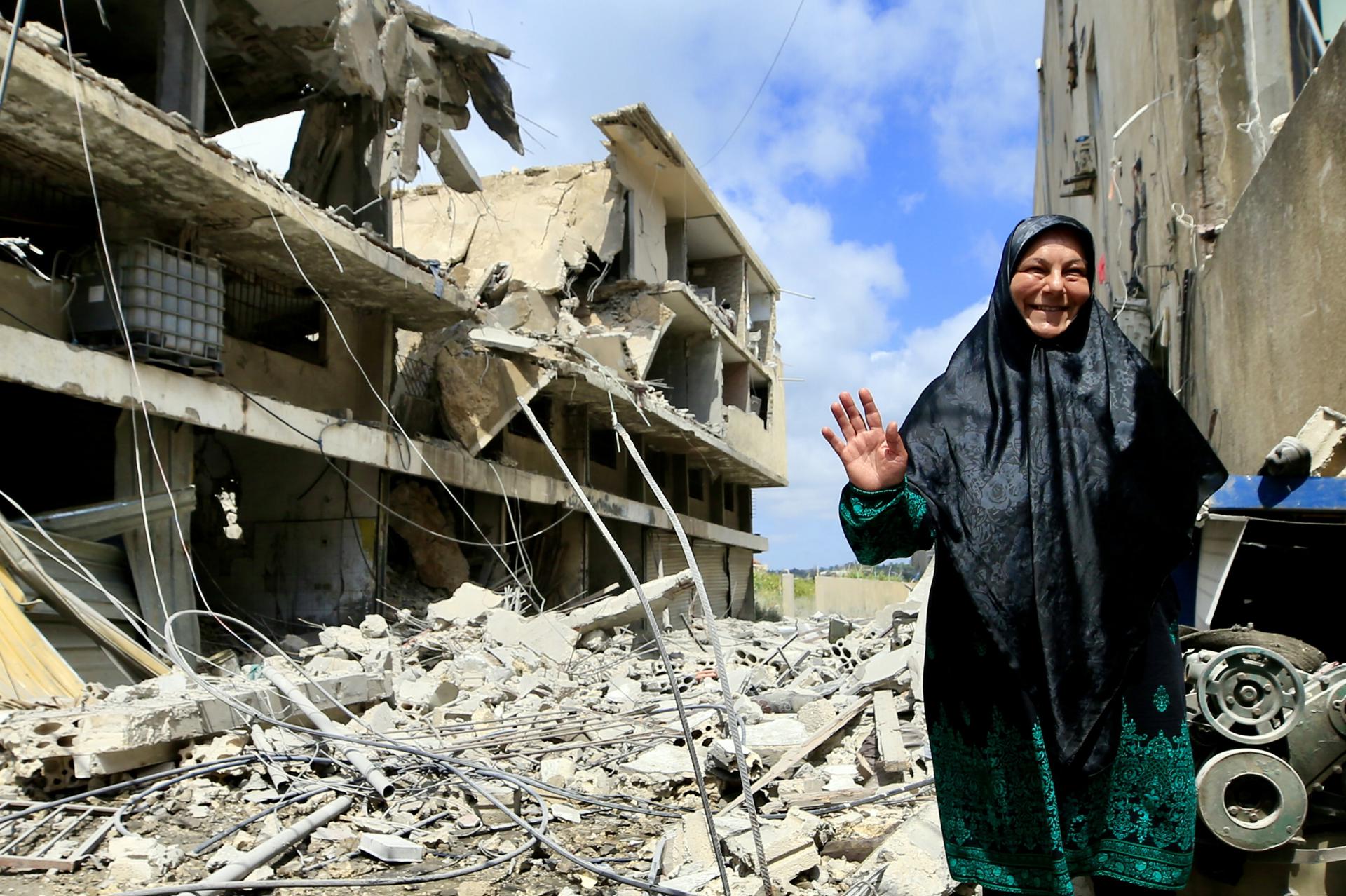 TYRE (Lebanon), 26/05/2026.- A woman walks past a partially damaged building following an Israeli airstrike in the southern port city of Tyre, Lebanon, 26 May 2026. Lebanon's Health Ministry said Israeli attacks across the country have killed more than 3,100 people and injured thousands more since renewed hostilities between Israel and Hezbollah began in early March. (Líbano, Hizbulá/Hezbolá) EFE/EPA/STRINGER