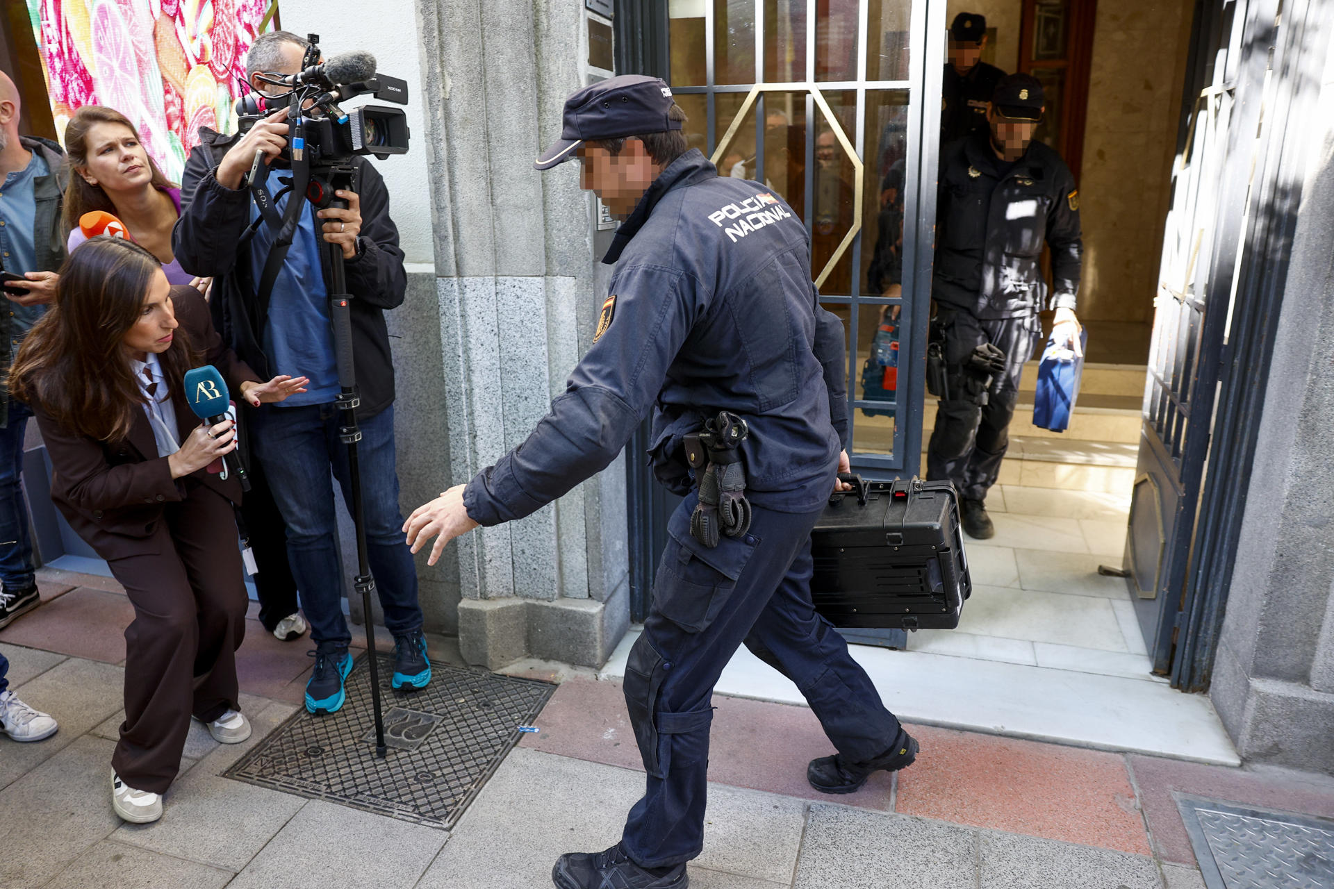 MADRID, 19/05/2026.- Agentes de la Policía Nacional salen del edificio donde se encuentra la oficina del expresidente del Gobierno José Luis Rodríguez Zapatero durante un registro este martes en Madrid. El juzgado central de instrucción número 4 de la Audiencia Nacional ha citado el próximo 2 de junio como imputado al expresidente del Gobierno, el leonés José Luis Rodríguez Zapatero por organización criminal, tráfico de influencias y falsedad en la causa que investiga supuestos cobros de comisiones ilegales en el rescate de la compañía aérea Plus Ultra. EFE/ Rodrigo Jiménez