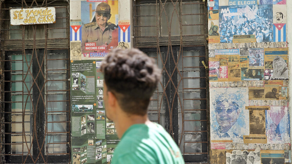 AME3435. LA HABANA (CUBA), 20/05/2026.- Una persona camina frente a una casa con carteles y propaganda política en su fachada este miércoles, en la Habana (Cuba). El Departamento de Justicia (DOJ) de Estados Unidos presentó una acusación criminal contra el expresidente cubano Raúl Castro por la muerte de cuatro aviadores de la organización Hermanos al Rescate hace 30 años, lo que eleva la presión contra La Habana. EFE/ Ernesto Mastrascusa