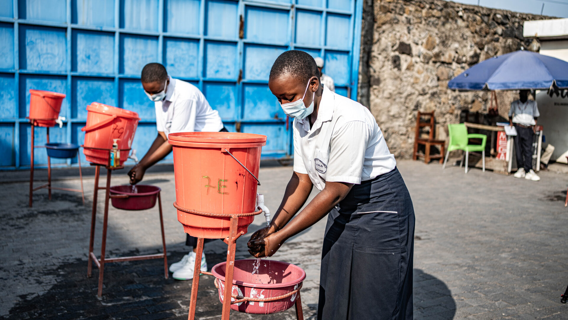 Vue de la cour du collège Mwanga à Goma. Des élèves se lavent les mains avant d'accéder à leurs cours dans le cadre des mesures de prévention contre Ebola. View of the courtyard of Mwanga College in Goma. Students wash their hands before entering their classes as part of Ebola disease prevention measures.