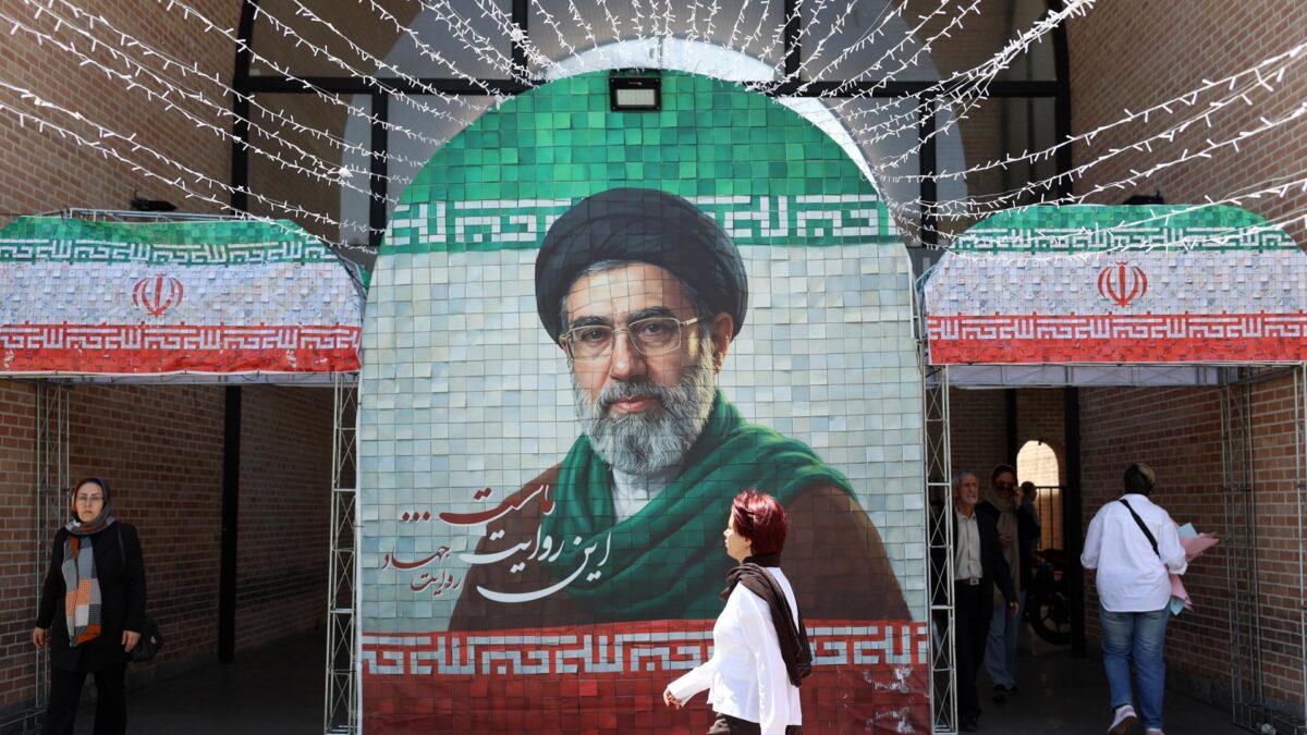 TEHRAN (Iran (Islamic Republic Of)), 06/05/2026.- Iranians walk next to a picture of Iran supreme leader Ayatollah Mojtaba Khamenei in a street in Tehran, Iran, 06 May 2026. US President Donald Trump announced pausing the operation of escorting ships through the Strait of Hormuz, hinting at progress in peace talks with Tehran. (Teherán) EFE/EPA/ABEDIN TAHERKENAREH