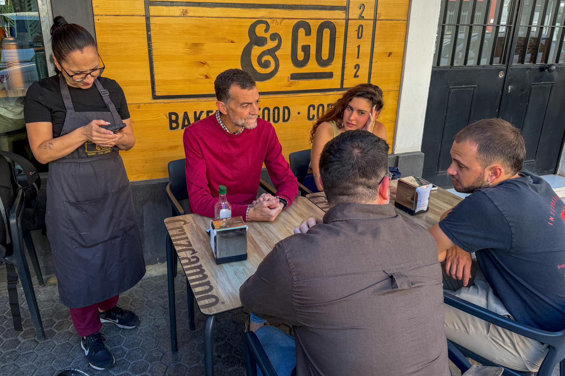 Antonio Maíllo (c), candidato de Por Andalucía, aprovecha la jornada de reflexión este sábado para pasear por el barrio sevillano de San Julián y realizar algunas compras cotidianas.
