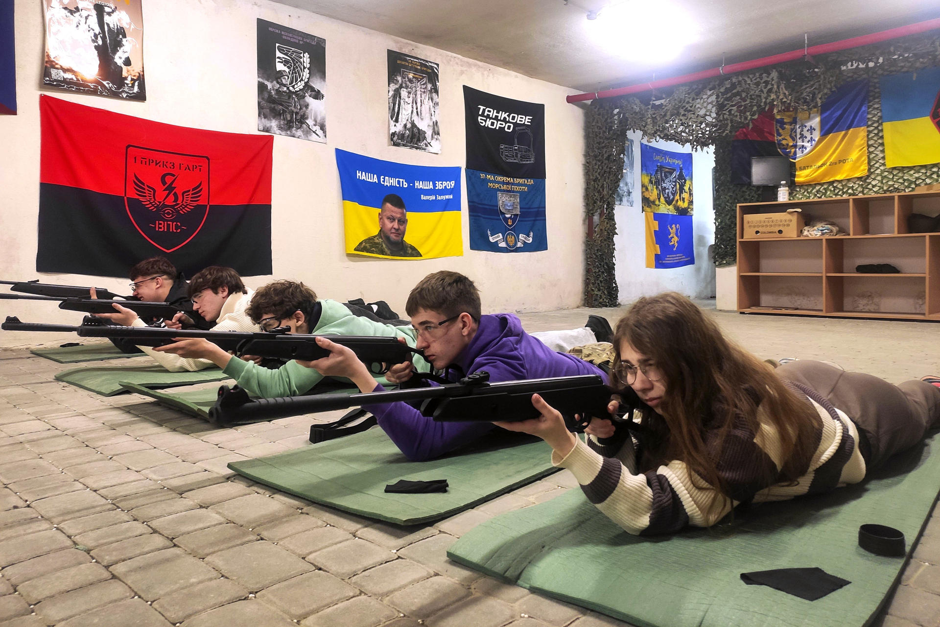 FOTODELDÍA LEÓPOLIS (UCRANIA), 21/05/2026.- Estudiantes ucranianos de entre 15 y 17 años adquieren habilidades básicas en el manejo de armas bajo la supervisión de instructores con experiencia en combate este jueves, en una escuela de Leópolis (Ucrania). A medida que la invasión rusa se acerca a su 52º mes, las escuelas secundarias ucranianas están pasando de las clases teóricas a la preparación militar práctica, con instructores con experiencia en combate que enseñan a los adolescentes habilidades básicas de combate y supervivencia. Más de 13.000 estudiantes de entre 15 y 17 años asisten a clases en más de una docena de centros especiales establecidos por las autoridades locales en Leópolis. El modelo de esta ciudad del oeste de Ucrania se está extendiendo ahora a todo el país, mientras el Estado prepara a una generación que podría enfrentarse a más años de conflicto. EFE/ Rostyslav Averchuk