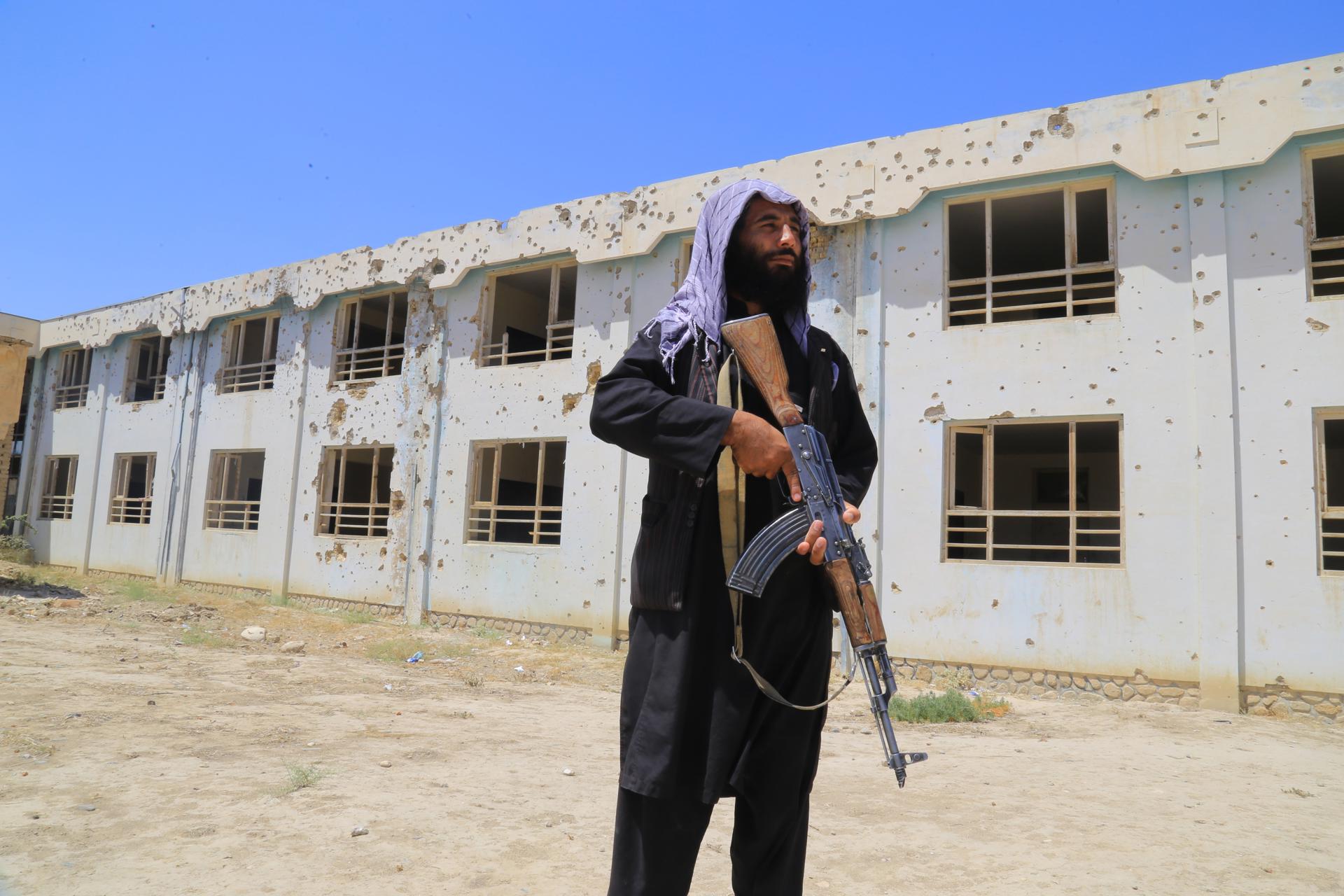 FARYAB (Afghanistan), 31/03/2026.- A Taliban security official stands guard as Afghan schoolchildren return to school after the start of the new academic year in Faryab, Afghanistan, 31 March 2026. Students, mostly boys, have returned to school with the start of the new academic year in Afghanistan's Faryab province, where many classrooms still show visible damage from years of conflict. In several districts, school buildings bear bullet marks, blast impacts, and structural cracks left from fighting between former Afghan forces and the Taliban. Despite the reopening, students continue their studies in unsafe and inadequate conditions, underscoring the ongoing challenges facing the education system and the need for reconstruction in war-affected areas. (Afganistán) EFE/EPA/STRINGER
