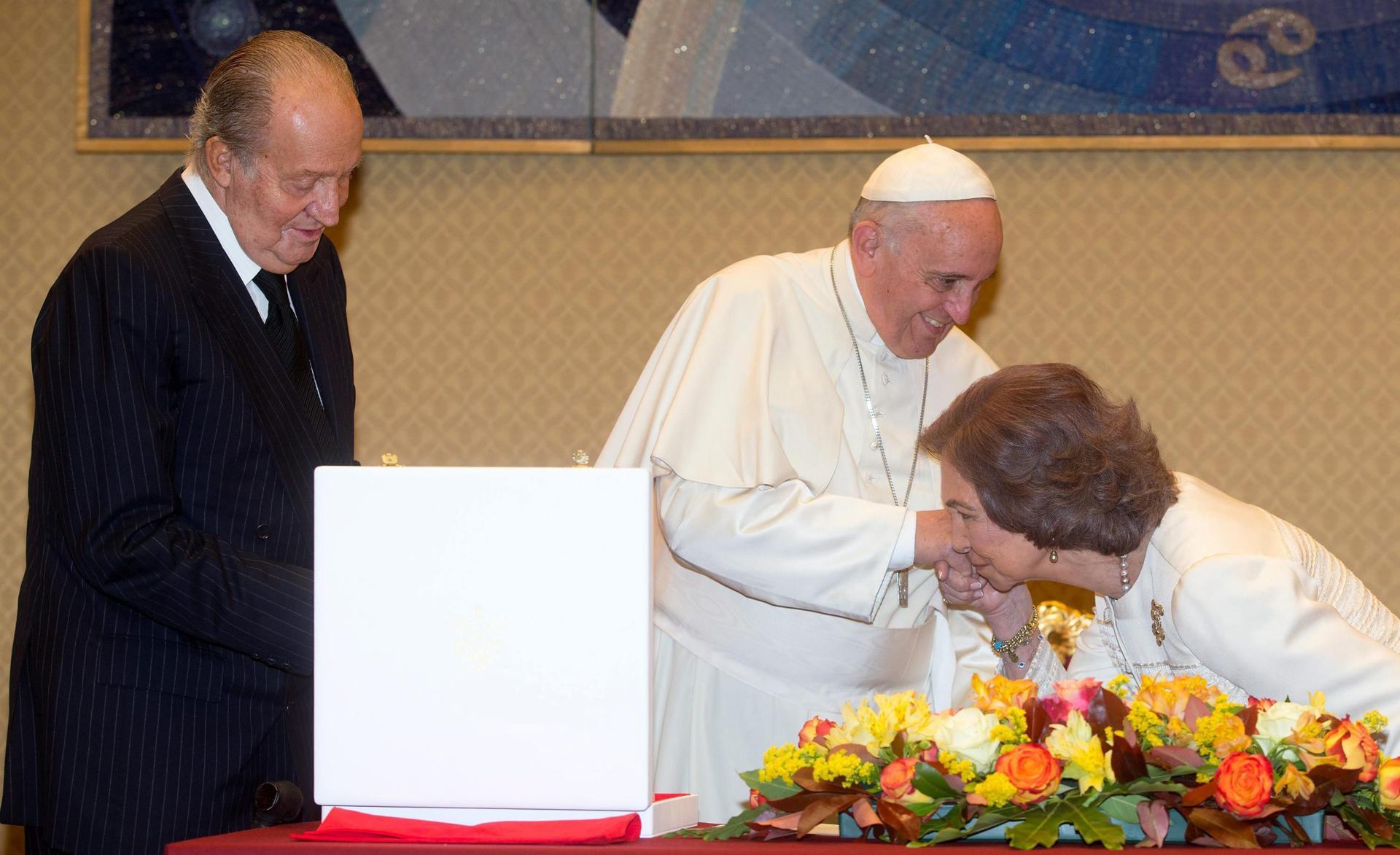 WSX458 CIUDAD DEL VATICANO (VATICANO) 28/04/2014.- El papa Francisco (c) recibe dos volúmenes con la obra mística de San Juan de la Cruz y Santa Teresa de Jesús de manos del rey don Juan Carlos I (L) y de la reina doña Sofía durante el tradicional intercambio de regalos en el ámbito una audiencia privada que el pontífice mantuvo con los reyes de España en el Vaticano, hoy, lunes 28 de abril de 2014. EFE/Claudio Peri, pool