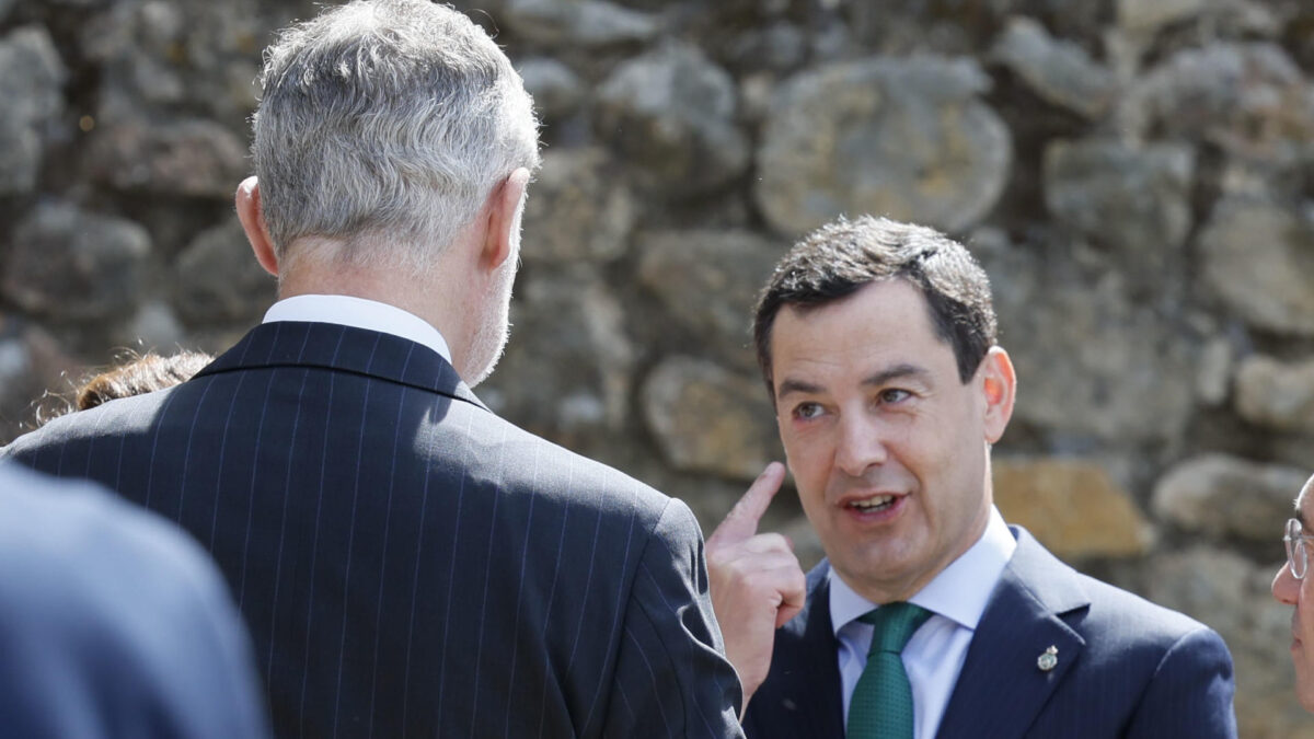 CUACOS DE YUSTE (CÁCERES) (ESPAÑA), 25/05/2026.- El presidente en funciones de Andalucía, Juanma Moreno (d) se señala un orzuelo ante el rey Felipe VI (i) a su llegada al acto de entrega del XIX Premio Europeo Carlos V, que en esta edición ha recaído en el Comité Europeo de las Regionales (CDR), que concede La Fundación Academia Europea e Iberoamericana de Yuste, en el Monasterio de San Jerónimo de Yuste (Cáceres). EFE/ Ballesteros