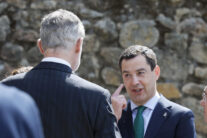 CUACOS DE YUSTE (CÁCERES) (ESPAÑA), 25/05/2026.- El presidente en funciones de Andalucía, Juanma Moreno (d) se señala un orzuelo ante el rey Felipe VI (i) a su llegada al acto de entrega del XIX Premio Europeo Carlos V, que en esta edición ha recaído en el Comité Europeo de las Regionales (CDR), que concede La Fundación Academia Europea e Iberoamericana de Yuste, en el Monasterio de San Jerónimo de Yuste (Cáceres). EFE/ Ballesteros