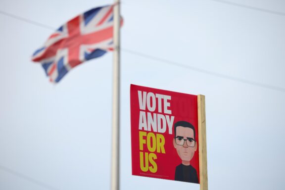 WIGAN (United Kingdom), 15/06/2026.- A Union Flag flies behind a placard supporting Labour candidate Andy Burnham in Wigan, Britain, 15 June 2026. A by-election will take place on 18 June in the parliamentary constituency of Makerfield after Labour MP Josh Simons stepped down to allow Mayor of Greater Manchester Andy Burnham to stand. (Reino Unido) EFE/EPA/ADAM VAUGHAN