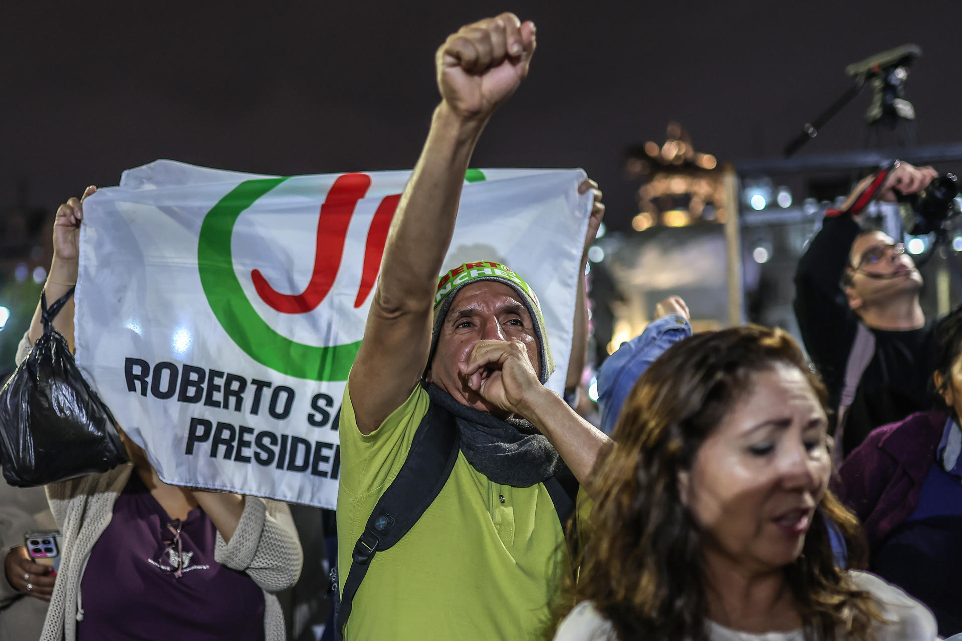 AME9628. LIMA (PERÚ), 07/06/2026.- Simpatizantes del candidato a la Presidencia de Perú Roberto Sánchez esperan a que se pronuncie tras los resultados de los sondeos a pie de urna durante la segunda vuelta de las elecciones este domingo, en la Plaza San Martín de Lima (Perú). EFE/ Aldair Mejía