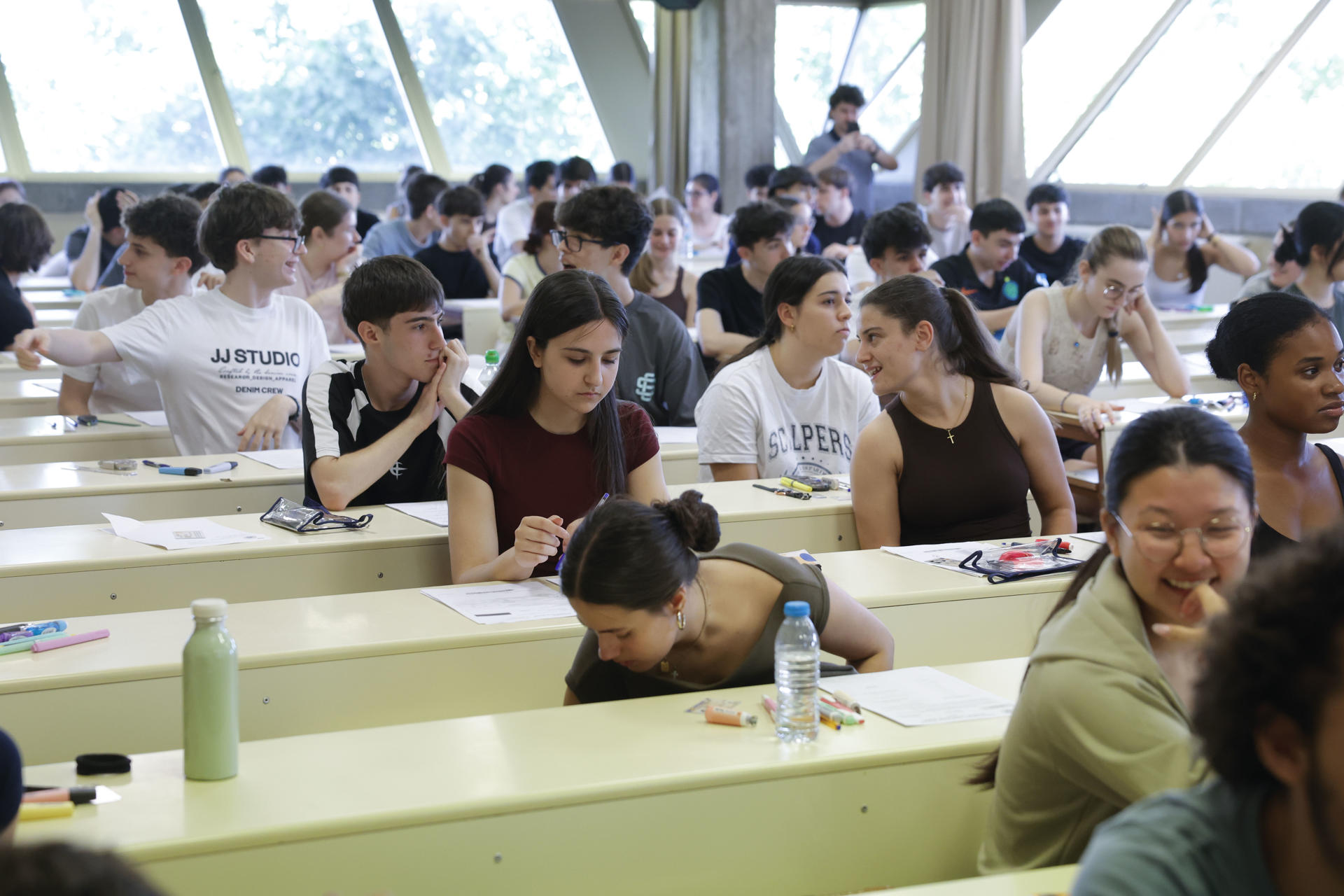 MADRID, 01/06/2026.- Varios estudiantes charlan antes de someterse a la Prueba de Acceso a la Universidad (PAU) 2026 en la Facultad de Ciencias de la Información de la Universidad Complutense de Madrid este lunes. La antigua selectividad arranca hoy en Madrid y Guadalajara y a partir del martes se sumará la mayoría de comunidades autónomas, en una edición que cada año tiene una carga más práctica y mayor tolerancia con las faltas de ortografía en asignaturas técnicas. EFE/ Zipi