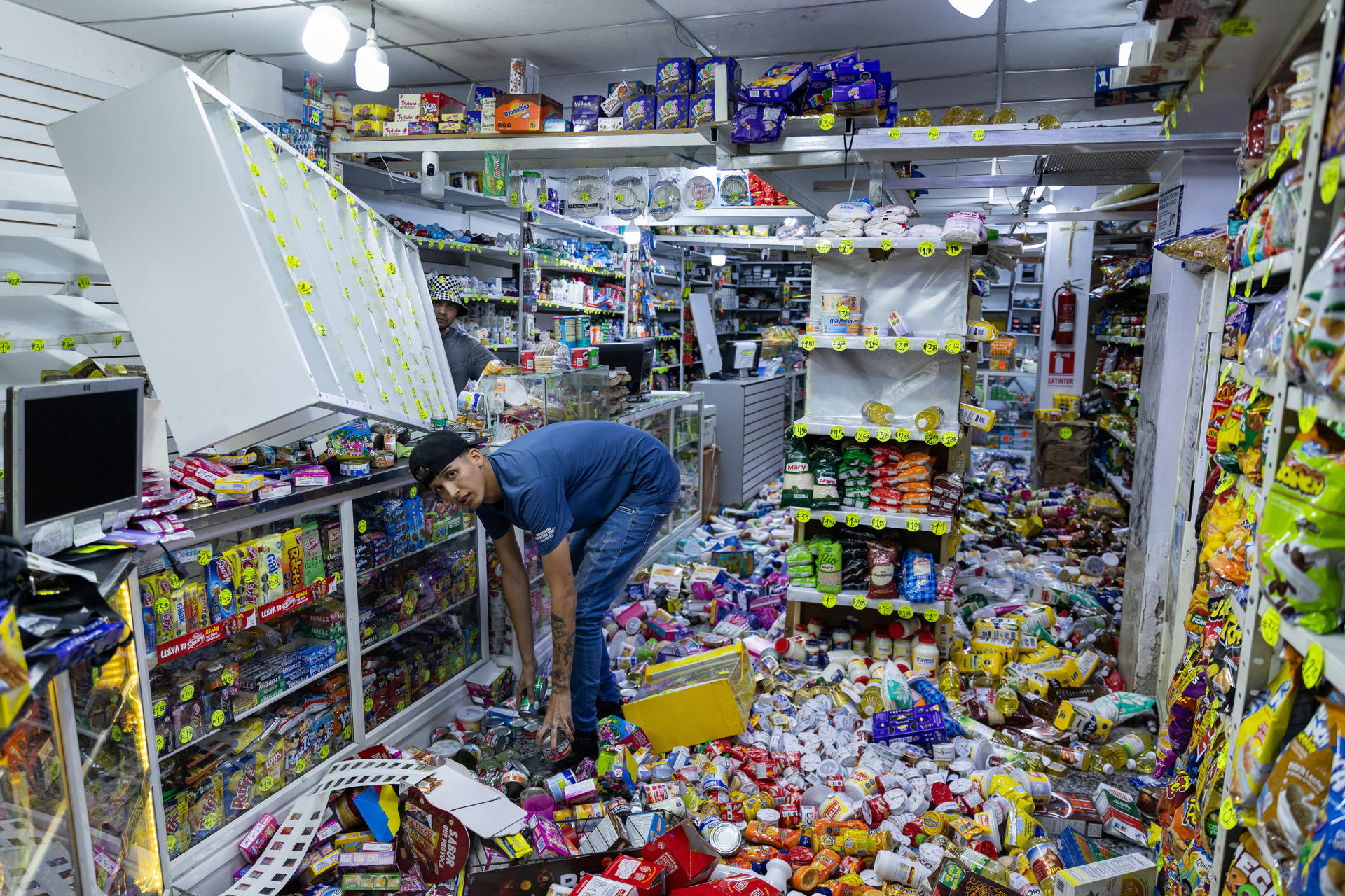 AME4138. CARACAS (VENEZUELA), 24/06/2026.- Una persona levanta alimentos en un almacén este miércoles, luego de dos fuertes terremotos que sacudieron el Caribe venezolano, en Caracas (Venezuela). El principal fue un sismo de magnitud 7,5, informó el sistema oficial de alerta de tsunamis de Estados Unidos. EFE/ Rayner Peña