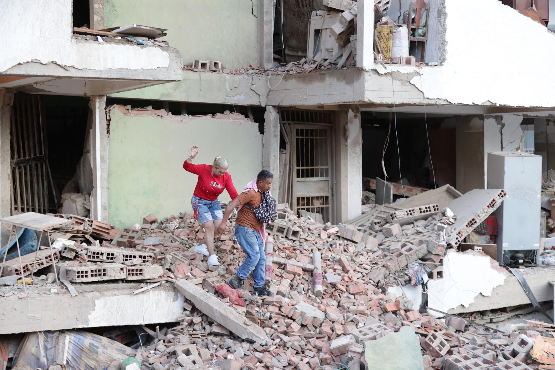 CATIA LA MAR (VENEZUELA), 25/06/2026.- Residentes caminan entre los escombros de una de las viviendas dañadas por los terremotos, en la localidad de Catia La Mar, en el estado costero de La Guaira (Venezuela) este jueves. EFE/ Ronald Pena R.