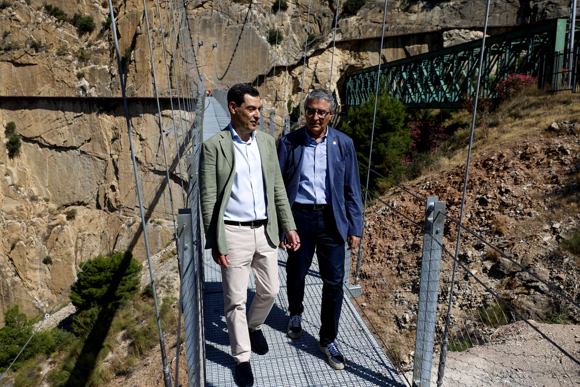 ARDALES (MÁLAGA), 09/06/2026.- El presidente de la Junta de Andalucía en funciones, Juanma Moreno (i), junto al presidente de la Diputación de Málaga, Francisco Salado, visitan el nuevo puente colgante de 110 metros, que es el más largo de España de estas características, hoy durante su inauguración en el Caminito del Rey de Málaga. EFE/Jorge Zapata