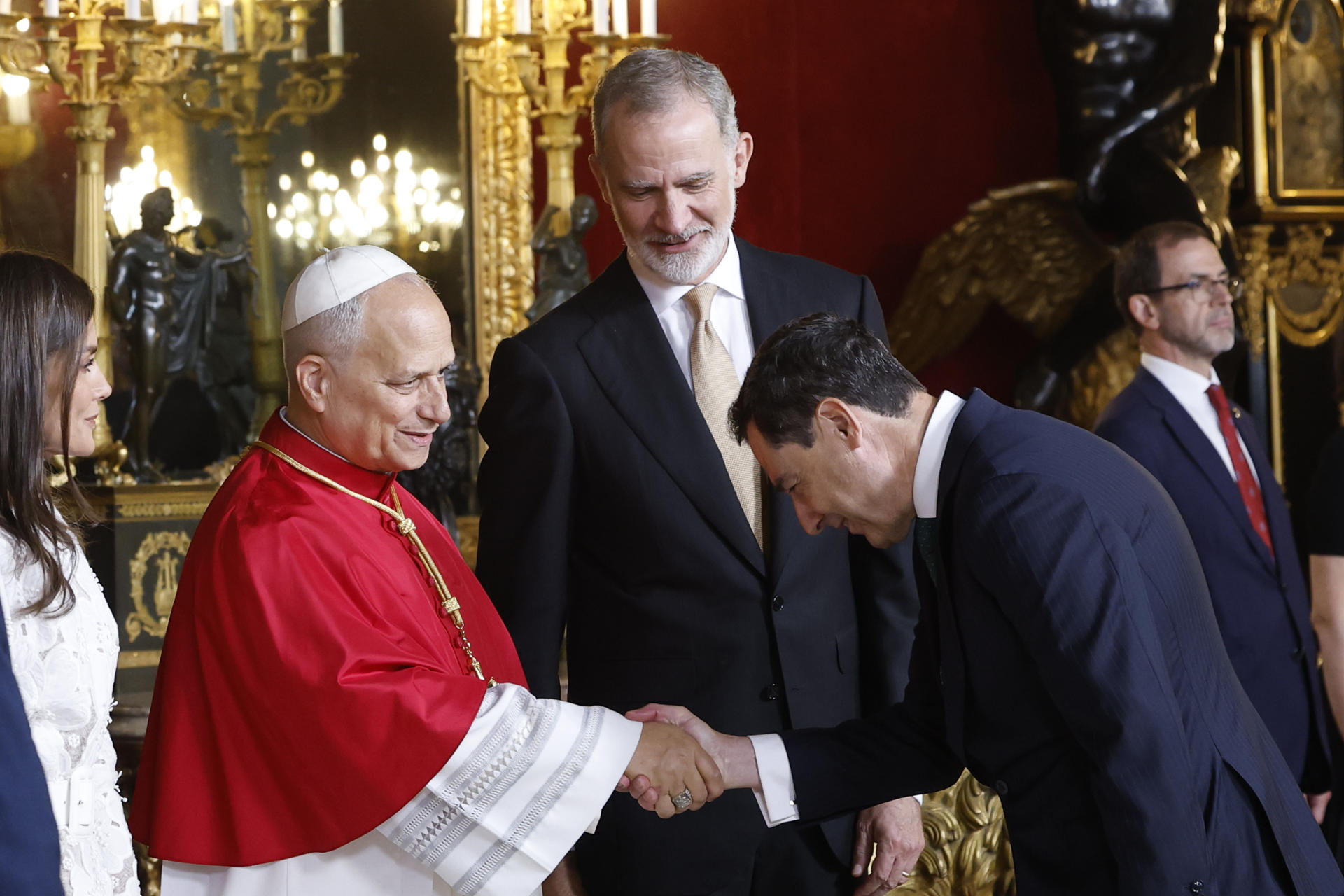 MADRID, 06/06/2026.- El presidente de la Junta de Andalucía, Juanma Moreno (d), saluda al papa León XIV en presencia del rey Felipe VI, durante el tradicional besamanos que ha tenido lugar en el Salón del Trono del Palacio Real, dentro de la ceremonia oficial de bienvenida al Sumo Pontífice que inicia este sábado en la capital un viaje de seis días a España. EFE/Chema Moya