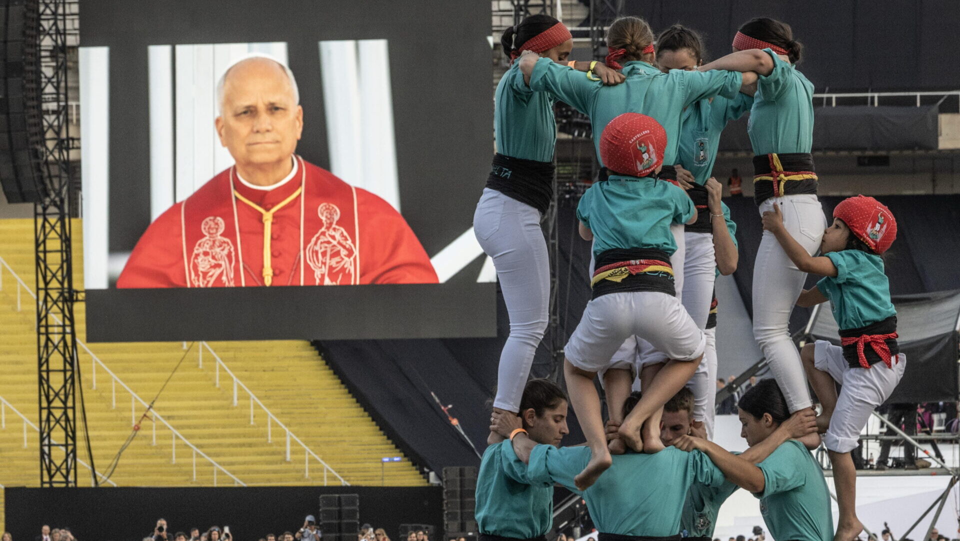 Barcelona (Spain), 09/06/2026.- People build a Catalan human tower as Pope Leo XIV, seen on a screen, arrives to attend a prayer vigil at the Lluís Companys Olympic Stadium in Barcelona, Spain, 09 June 2026. Pope Leo XIV is visiting Spain from 06 to 12 June 2026, with stops in Madrid, Barcelona and the Canary Islands. (Papa, España) EFE/EPA/CIRO FUSCO