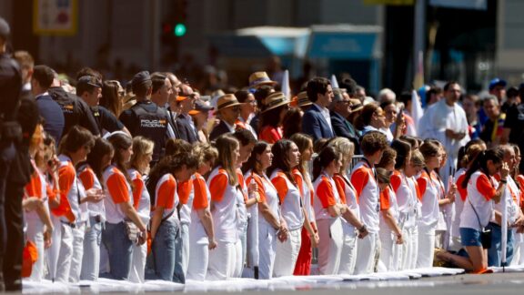Voluntarios se arrodillan ante el paso de León XIV en el papamóvil.