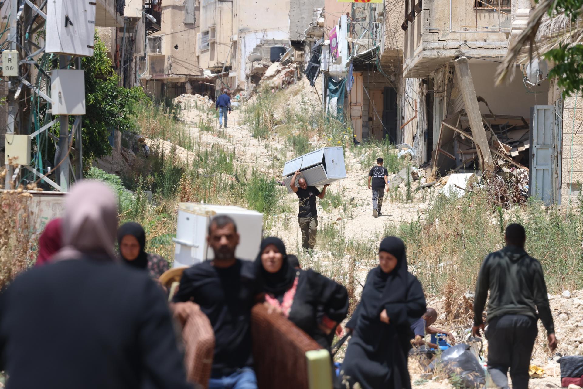 TULKAREM (-), 17/06/2026.- Displaced Palestinians carry their belongings through through theTulkarem refugee camp in the West Bank city of Tulkarm, 17 June 2026, as the Israeli military continues its long-term deployment across the city and its two refugee camps. EFE/EPA/ALAA BADARNEH