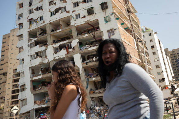 AME4837. CATIA LA MAR (VENEZUELA), 26/06/2026.- Personas reaccionan frente a edificios afectados por terremotos este jueves, en Catia La Mar (Venezuela). El presidente del Parlamento de Venezuela, el chavista Jorge Rodríguez, informó que los fallecidos por los dos terremotos ocurridos el miércoles en su país ya dejan 920 muertos y 3.360. EFE/ Ronald Peña R