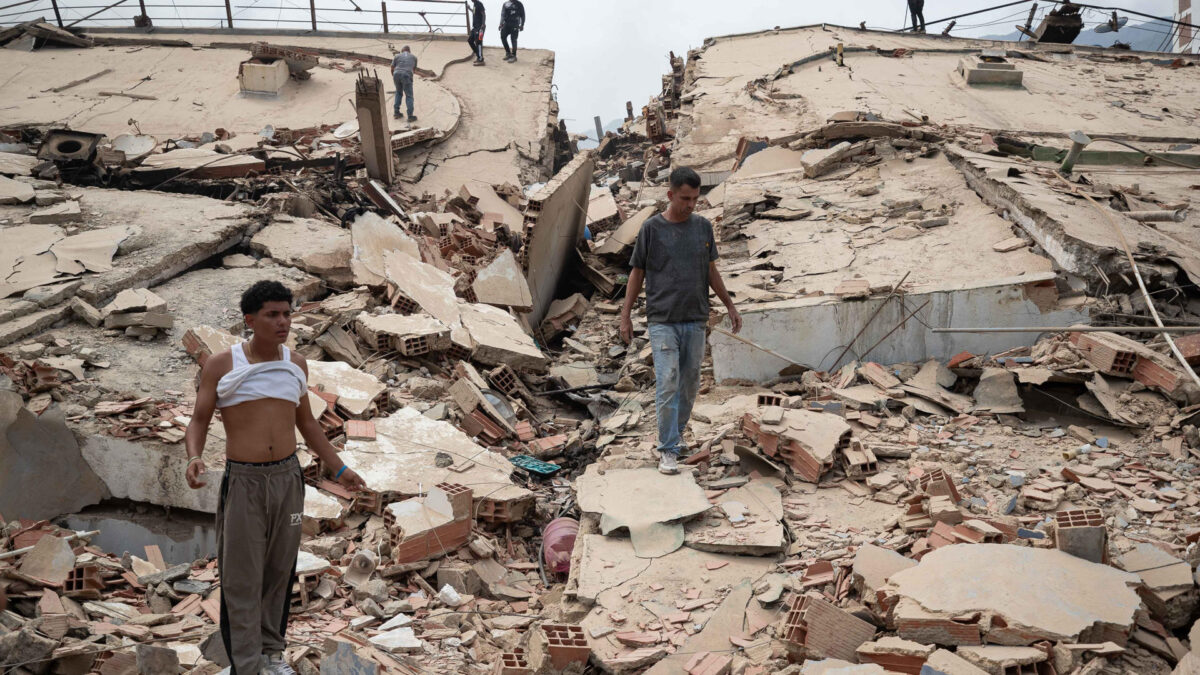 AME4353. LA GUAIRA (VENEZUELA), 25/06/2026.- Personas caminan por escombros de edificios afectados por terremotos este jueves, en La Guaira (Venezuela). El número de fallecidos en Venezuela a causa de los dos terremotos del miércoles se elevó a 188 y el de heridos a 1.520, mientras que al menos 346 construcciones, entre edificios, hospitales y centros comerciales, resultaron afectadas, informó el presidente de la Asamblea Nacional (AN, Parlamento), el chavista Jorge Rodríguez. EFE/ Ronald Peña R.