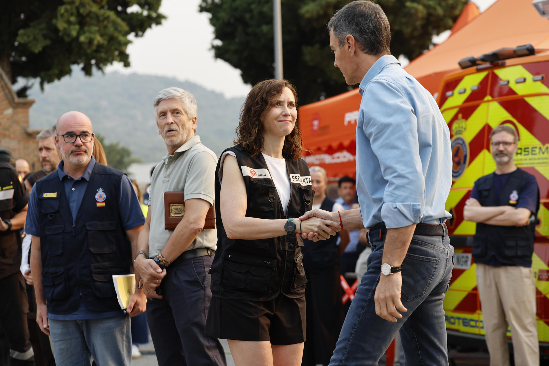 CENICIENTOS (C. DE MADRID), 25/07/2026.- El presidente del Gobierno, Pedro Sánchez, saluda a la presidenta de la Comunidad de Madrid, Isabel Díaz Ayuso (2d), a su llegada al Puesto de Mando Avanzado (PMA) ubicado en la localidad madrileña de Cenicientos, este sábado. Las llamas siguen devorando parte de la Comunidad de Madrid y la provincia de Ávila en unos incendios extremos, que han consumido ya unas 20.000 hectáreas y han obligado a desalojar o confinar a 60.000 personas mientras avanzan sin control, aunque las autoridades ven una oportunidad en los trabajos de extinción debido a la mejoría de las condiciones meteorológicas. EFE/Mariscal