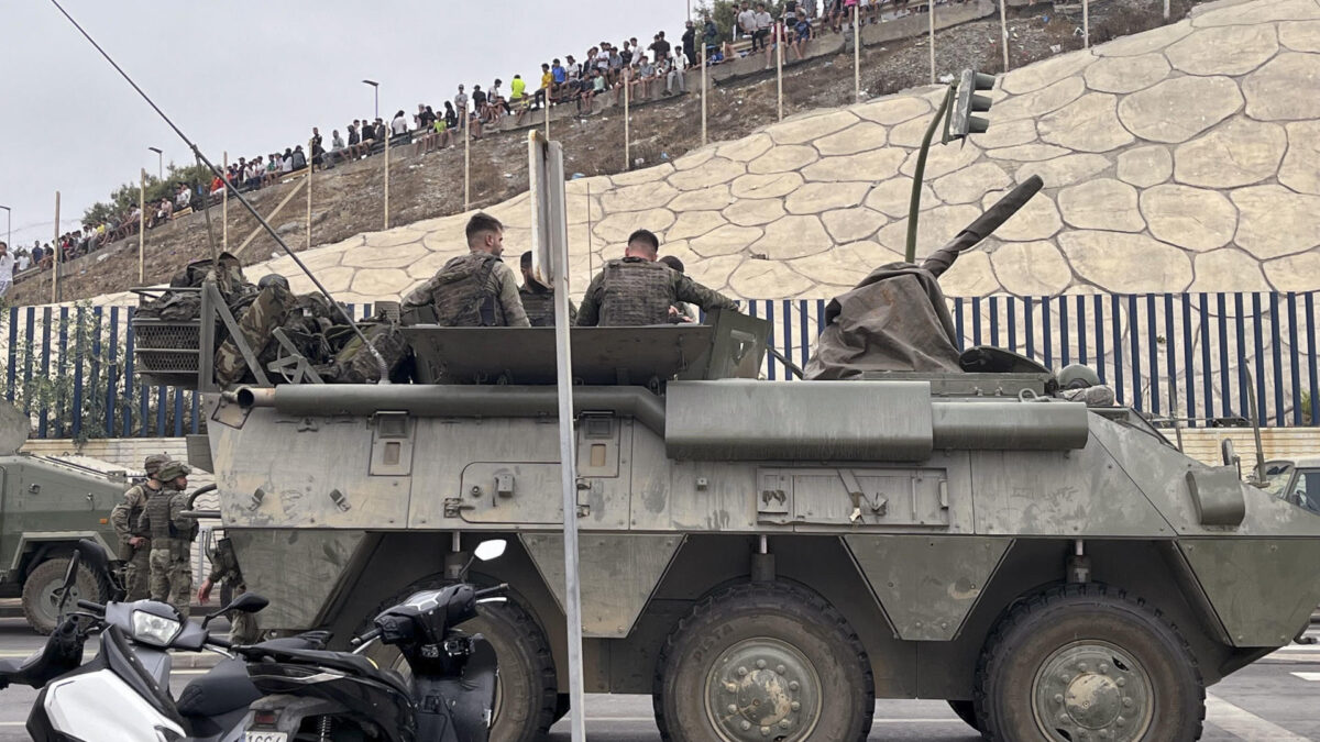 El ejército desplegando en la frontera del Tarajal en Ceuta ante la atenta mirada de los inmigrantes este viernes, donde se han registrado violentos enfrentamientos en los perímetros fronterizos durante su intento de acceder desde Marruecos hacia Ceuta y Melilla. EFE/ Reduan Dris