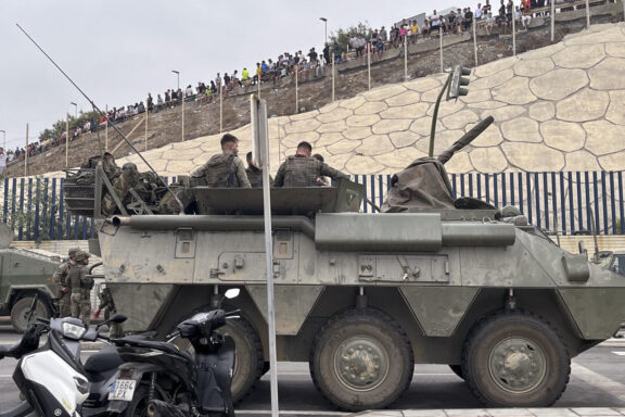 El ejército desplegando en la frontera del Tarajal en Ceuta ante la atenta mirada de los inmigrantes este viernes, donde se han registrado violentos enfrentamientos en los perímetros fronterizos durante su intento de acceder desde Marruecos hacia Ceuta y Melilla. EFE/ Reduan Dris