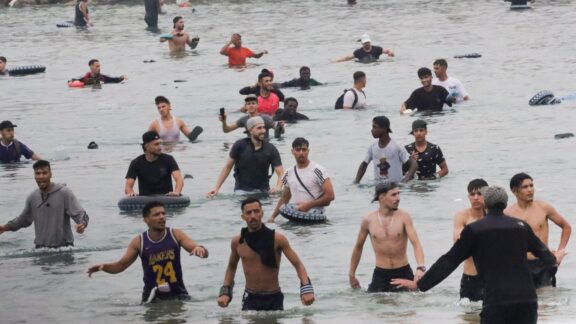 Un grupo de inmigrantes en la playa junto al paso fronterizo del Tarajal en Ceuta.
