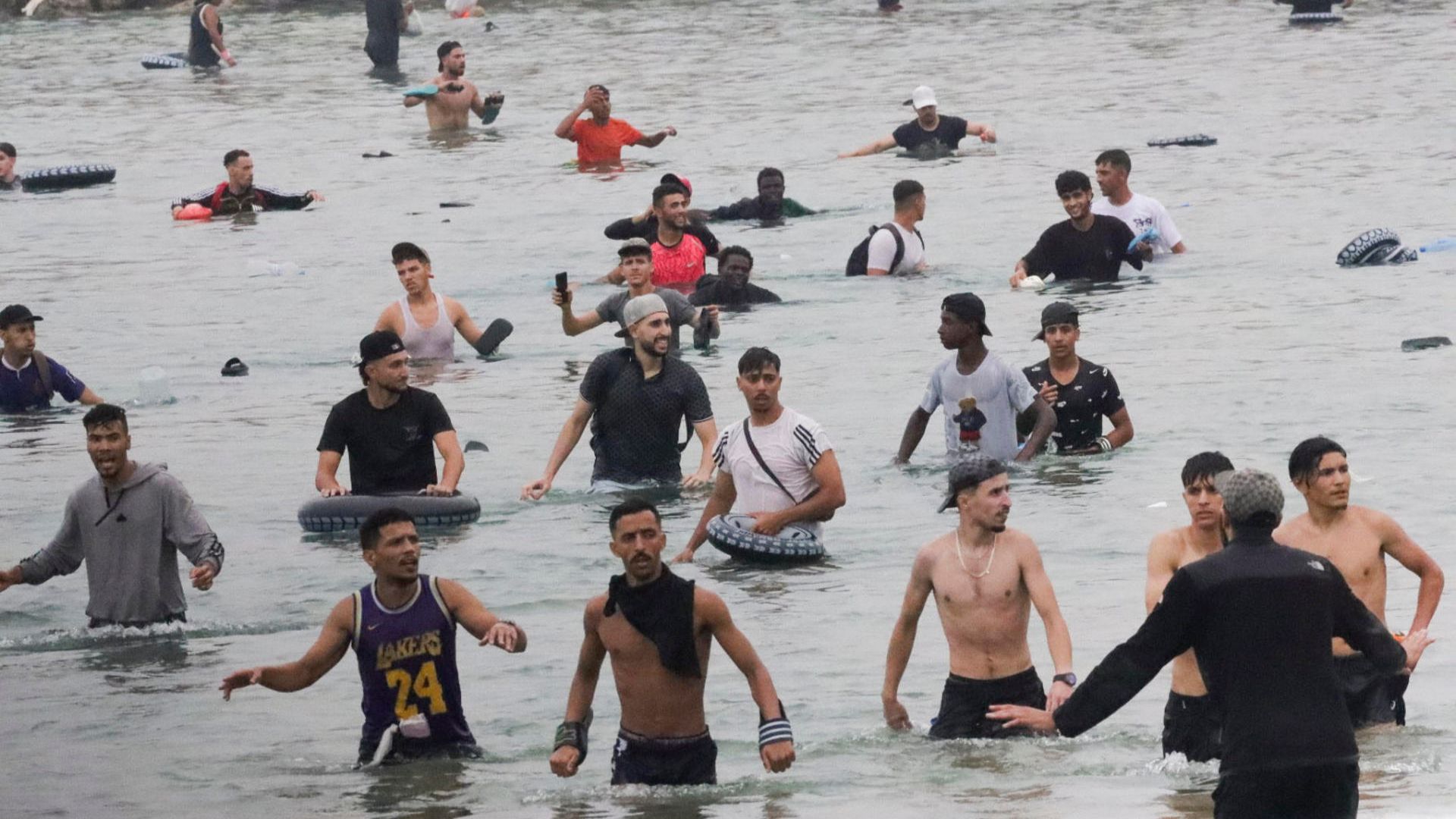 Un grupo de inmigrantes en la playa junto al paso fronterizo del Tarajal en Ceuta.