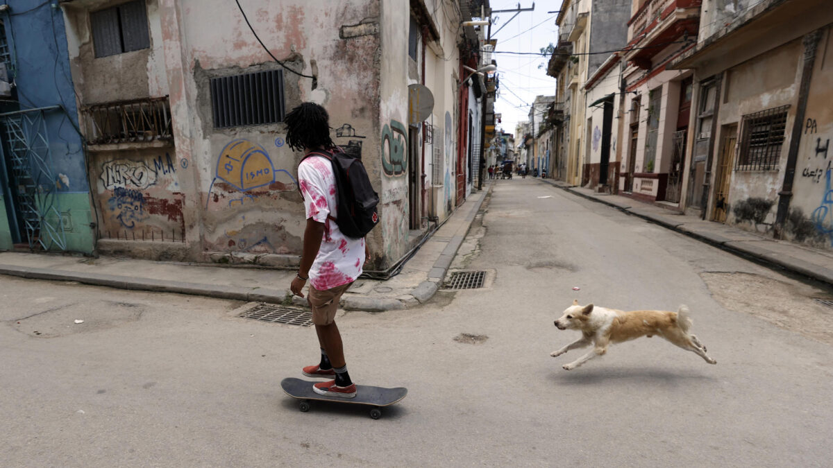AME1547. LA HABANA (CUBA), 20/07/2026.- Fotografía del 9 de julio de 2026 de una persona en patineta junto a un perro en una calle de La Habana (Cuba). Cinco reconocidos economistas cubanos presentaron este lunes una propuesta de reforma económica "integral" para la isla que, aseguran, "debe ir acompañada de una transformación política e institucional". EFE/ Ernesto Mastrascusa